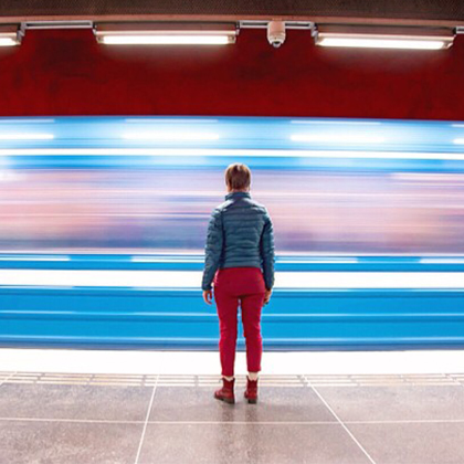 Person standing on the subway platform with train passing by